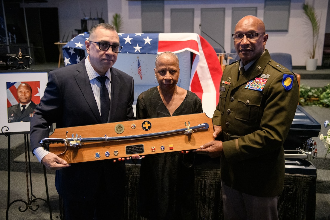 Ken Salas and Jackie Platt-Whitfield present Major Gen. Rodney Boyd, Adjutant General of the State of Illinois with a saber that belonged to retired Brig. Gen. Walter J. Whitfield Sept. 9, 2024