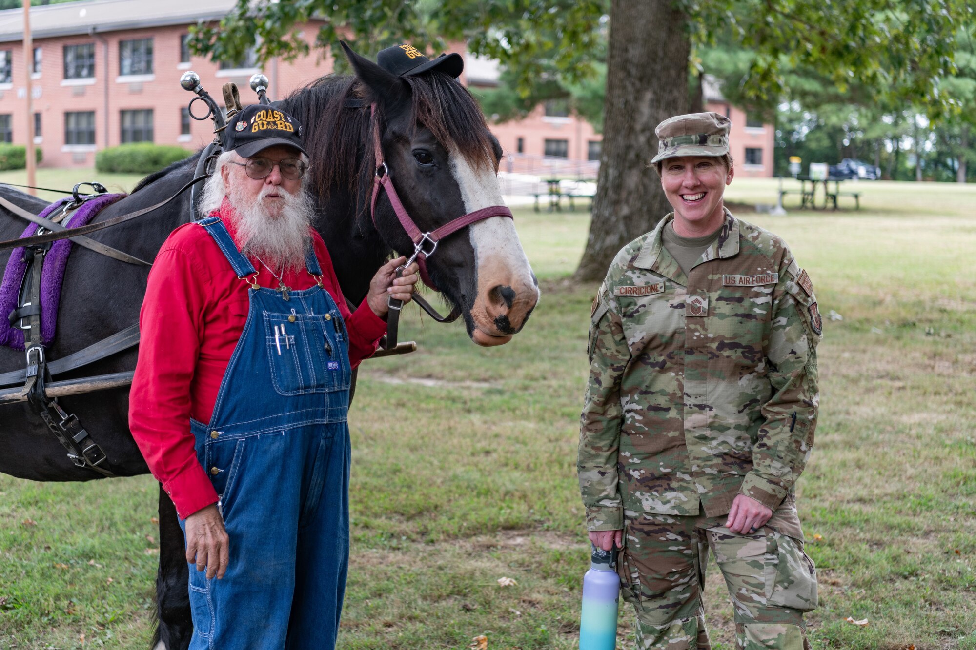 Chief Master Sgt. Jennifer Cirricione, senior enlisted leader of Arnold Engineering Development Complex poses with Woodye Bedford and his horse, “C. Moore.” Bedford provided carriage rides for attendees at the Veterans Appreciation Picnic Sept. 6, 2024, at the Arnold Lakeside Complex at Arnold Air Force Base, Tenn. (U.S. Air Force photo by Keith Thornburgh)