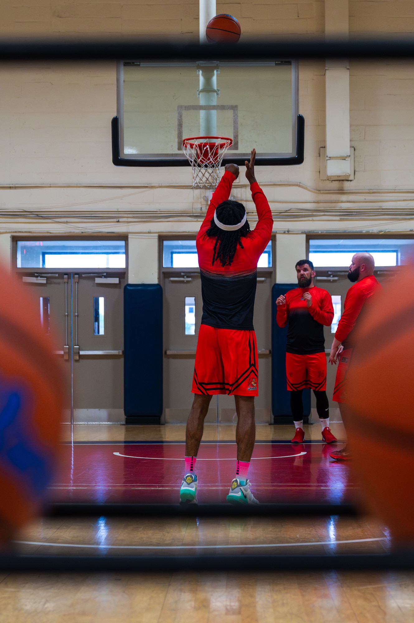 A basketball team warms up by shooting free throws.
