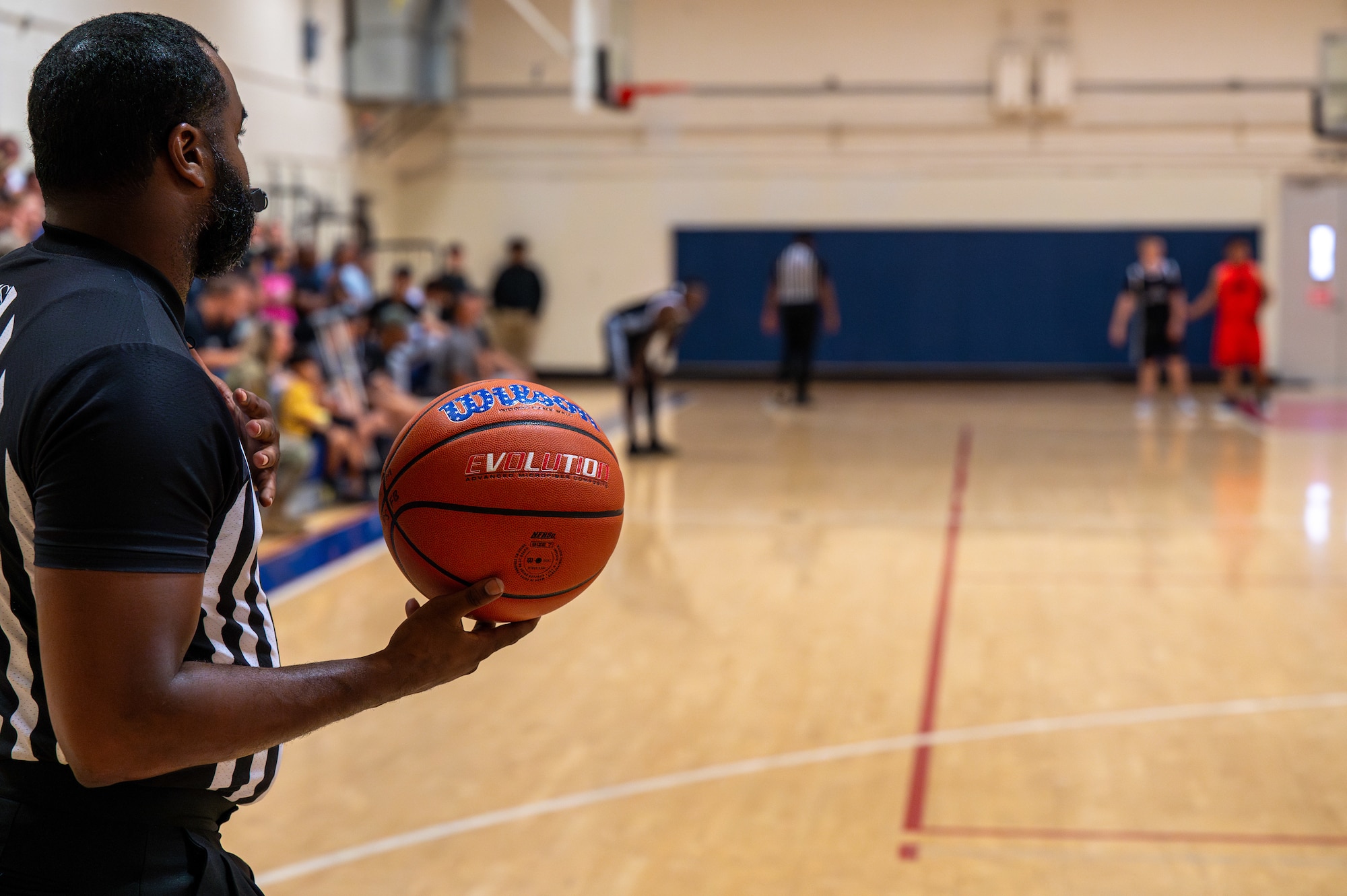A referee holds a basketball.