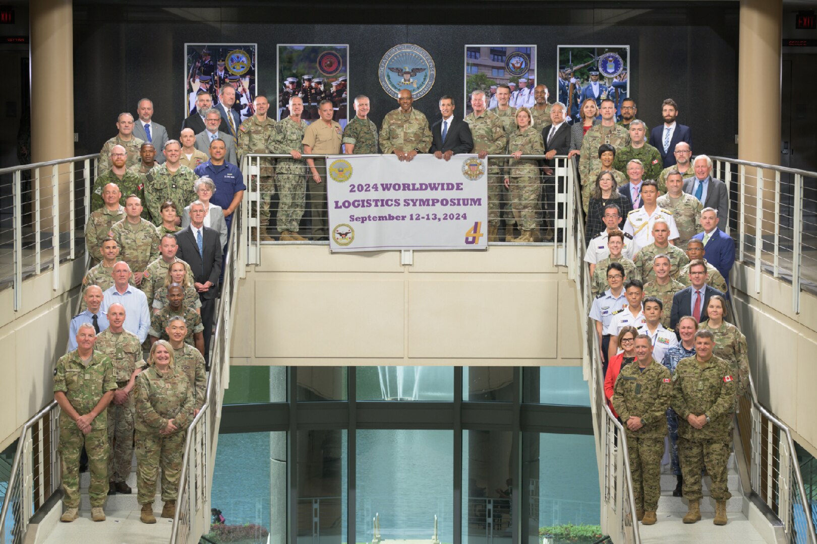 A group of people pose for a photo on two stairwells connected by the second floor.