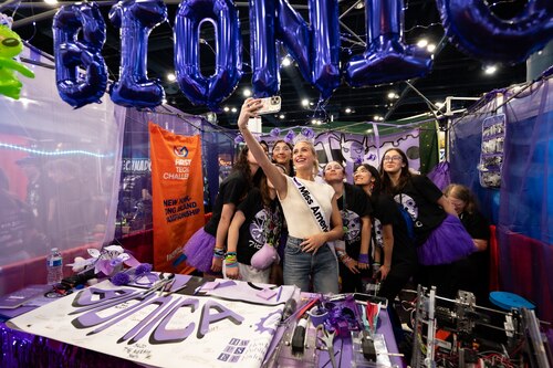 woman in Miss America crown and sash takes selfie with group of female high school students