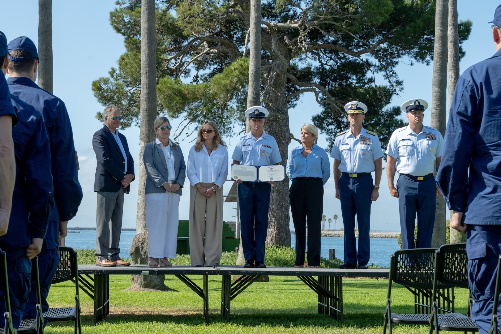 Seven people are seen standing on a stage at an award ceremony.