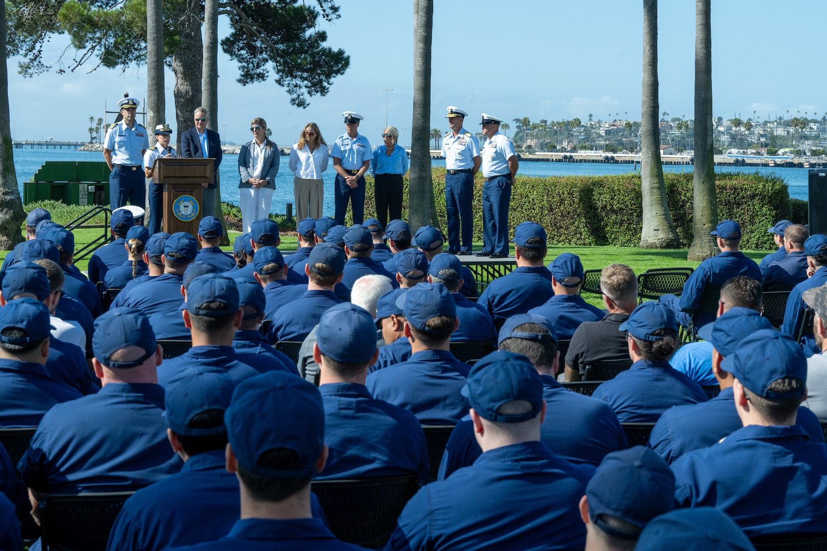 A crowd of seated Coast Guardsmen are seen attending an award ceremony.