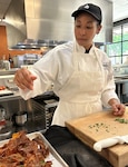 student sprinkles parsley over sweet potato chips