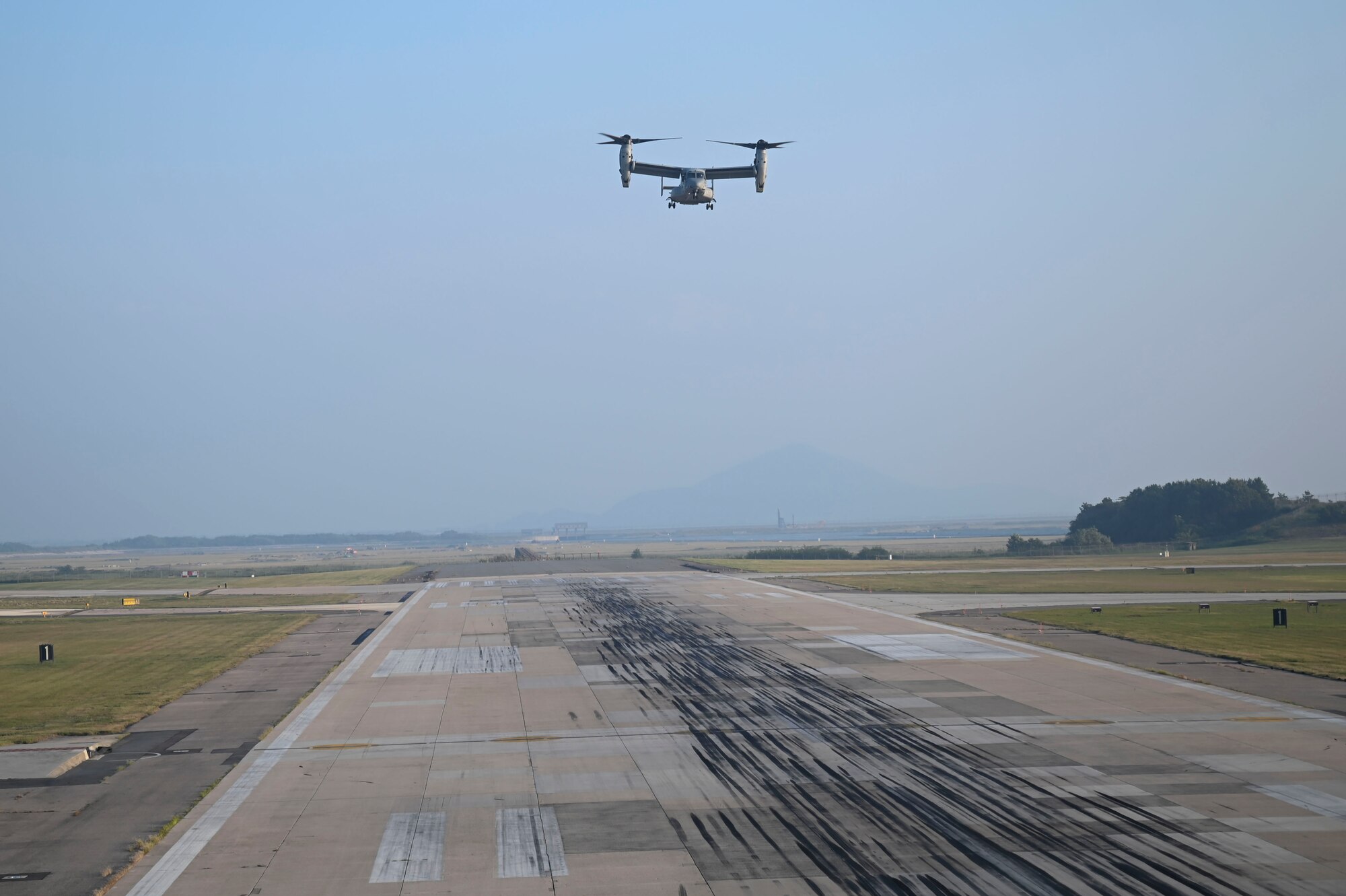 A U.S. Marine Corps MV-22B Osprey aircraft prepares to land on the runway.