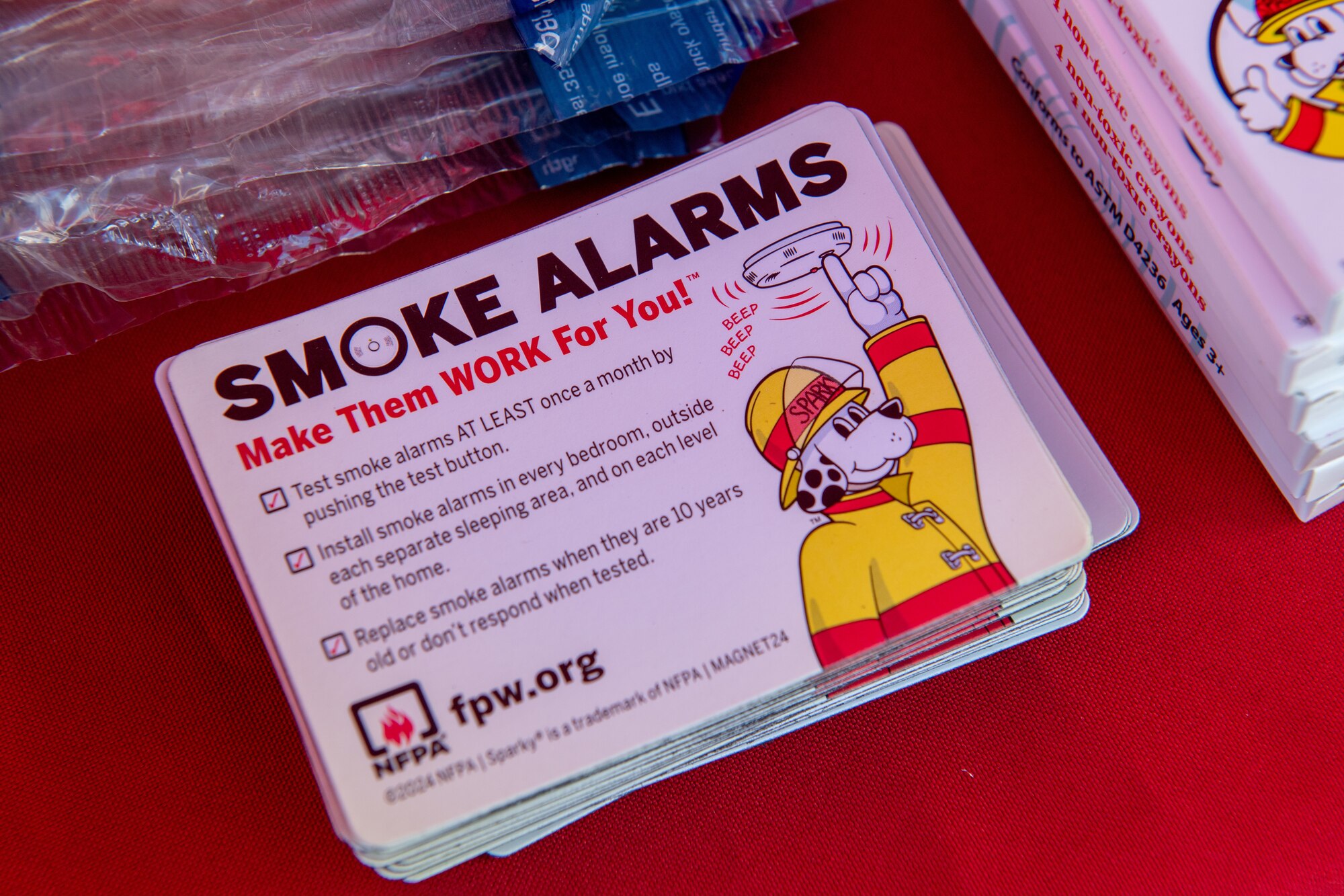 Fire Prevention Week magnets themed "Smoke Alarms: Make Them Work for You" are displayed for participants to take.