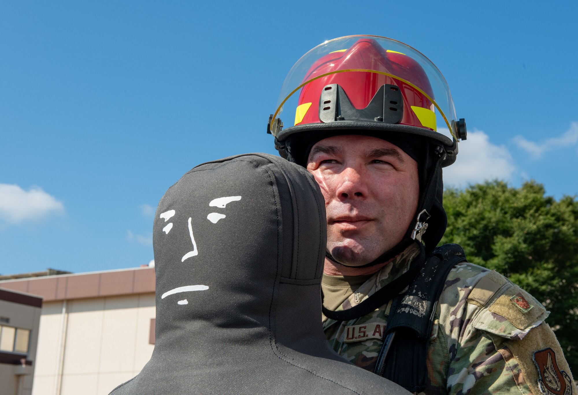 A fire muster challenge participant carries a dummy.