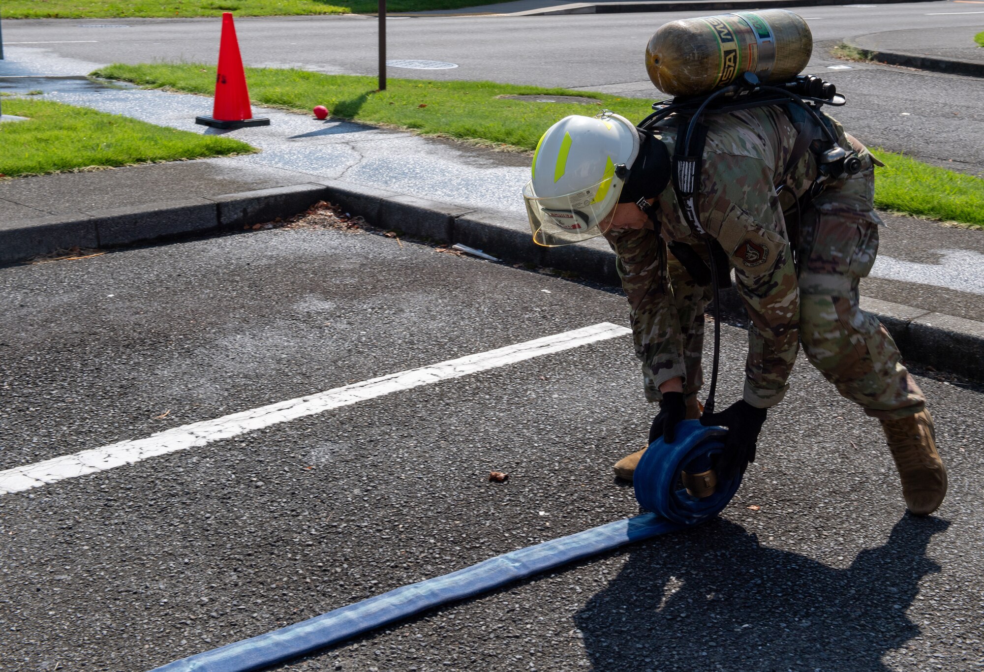 A fire muster challenge participant rolls a fire hose.