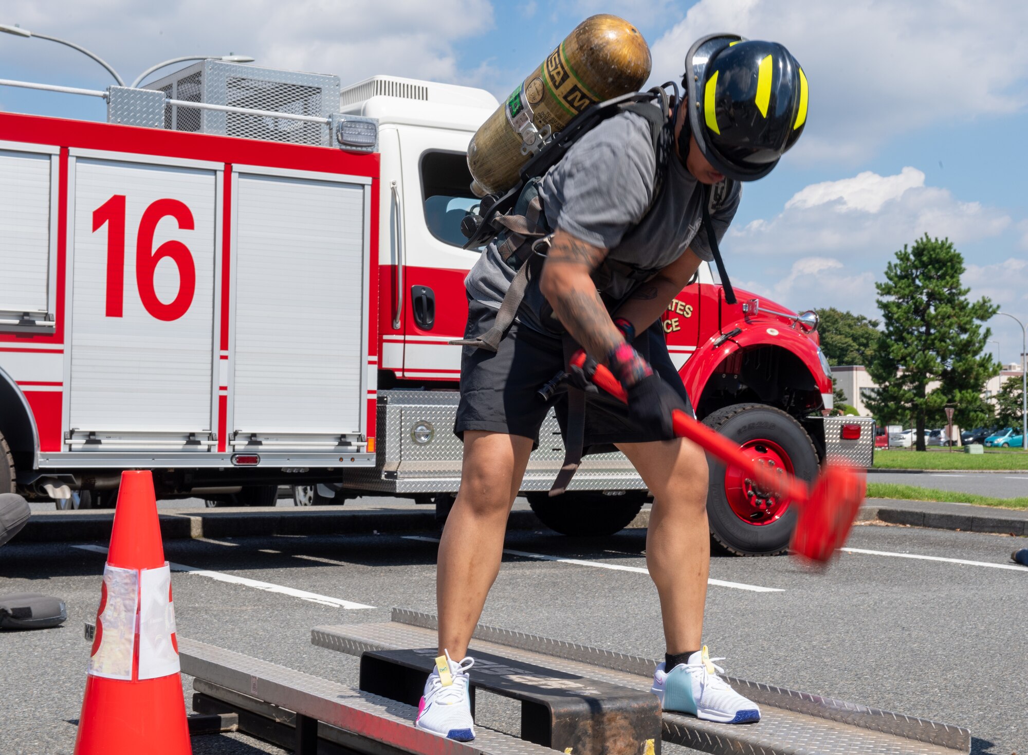 A person swings a hammer as part of the fire muster challenge.