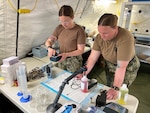 Hospital Corpsmen 2nd Class Kaitlyn Boyle and Jacqueline Holman of Forward Deployable Preventive Medicine Unit (FDPMU) East, Navy Environmental Preventive Medicine Unit TWO, process water samples at ISB Mielec, Poland, a staging area for the 82nd Airborne Division. The FDPMU supports public health for deployed service members, ensuring medical readiness and Force Health Protection. FDPMUs are required to complete a rigorous nine-to-12-month training and an Operational Readiness Evaluation (ORE) before certification by Commander, Naval Medical Forces Atlantic. Once certified, they are always prepared for immediate action, with two teams on the watch always. The teams provide public health support to units like Task Force Dragon, conducting site assessments and water safety evaluations. (U.S. Navy courtesy photo)