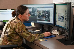 An Airman reads a weather report on a computer.