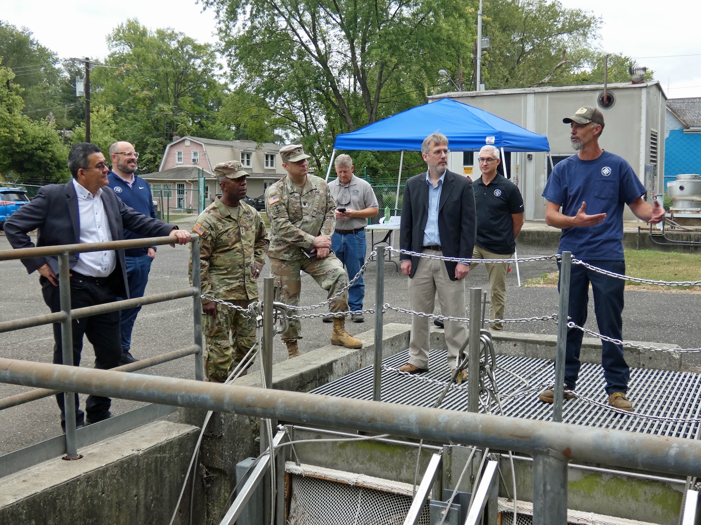 Team members gathered around water treatment plant infrastructure discuss a project
