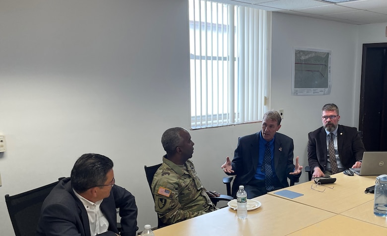 Team members gather for a briefing in a conference room