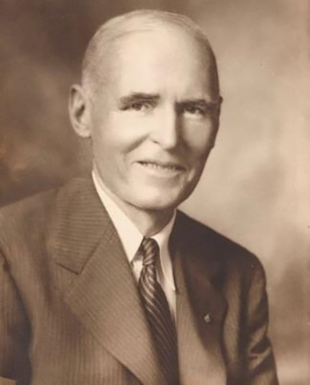 A man in a suit poses for a photo.