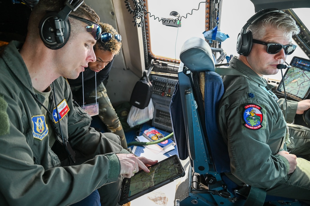 Maj. Luke Luecke, 68th Airlift Squadron C-5 pilot, shows Junelle Vasquez, a FedEx operations manager, C-5 navigational data while Lt. Col. Aaron Lewton, 68th Airlift Squadron C-5 pilot, flies the C-5 over Texas, Sept. 14, 2024.