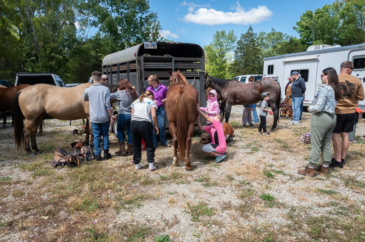 Young riders learn how to work around horses during a horsemanship class