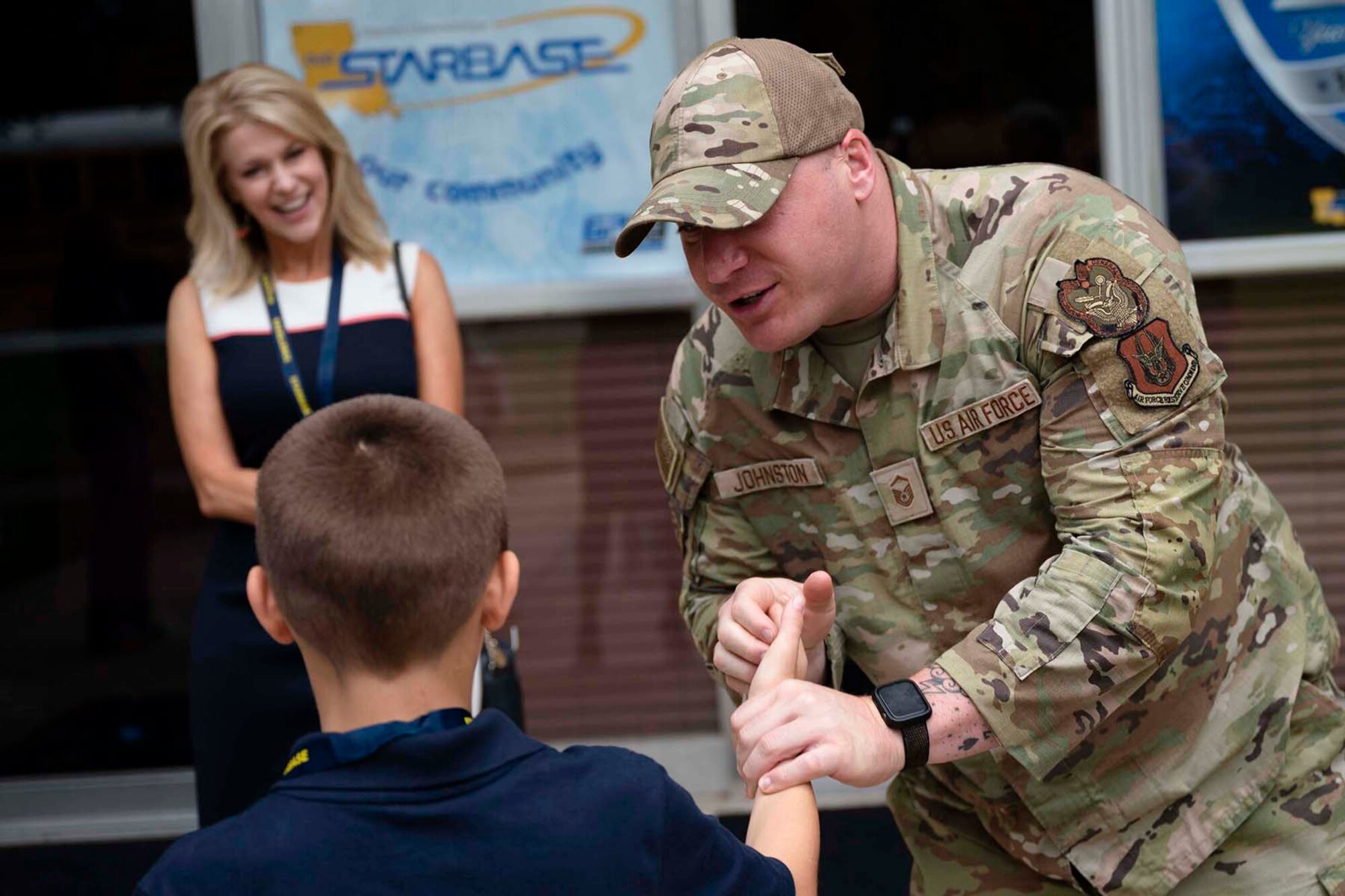Airman shakes hands with student