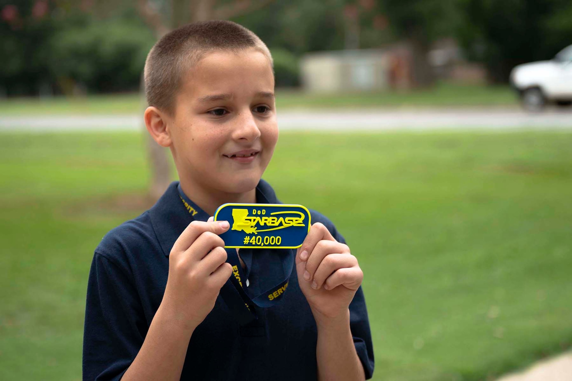 Student holds a badge while smiling