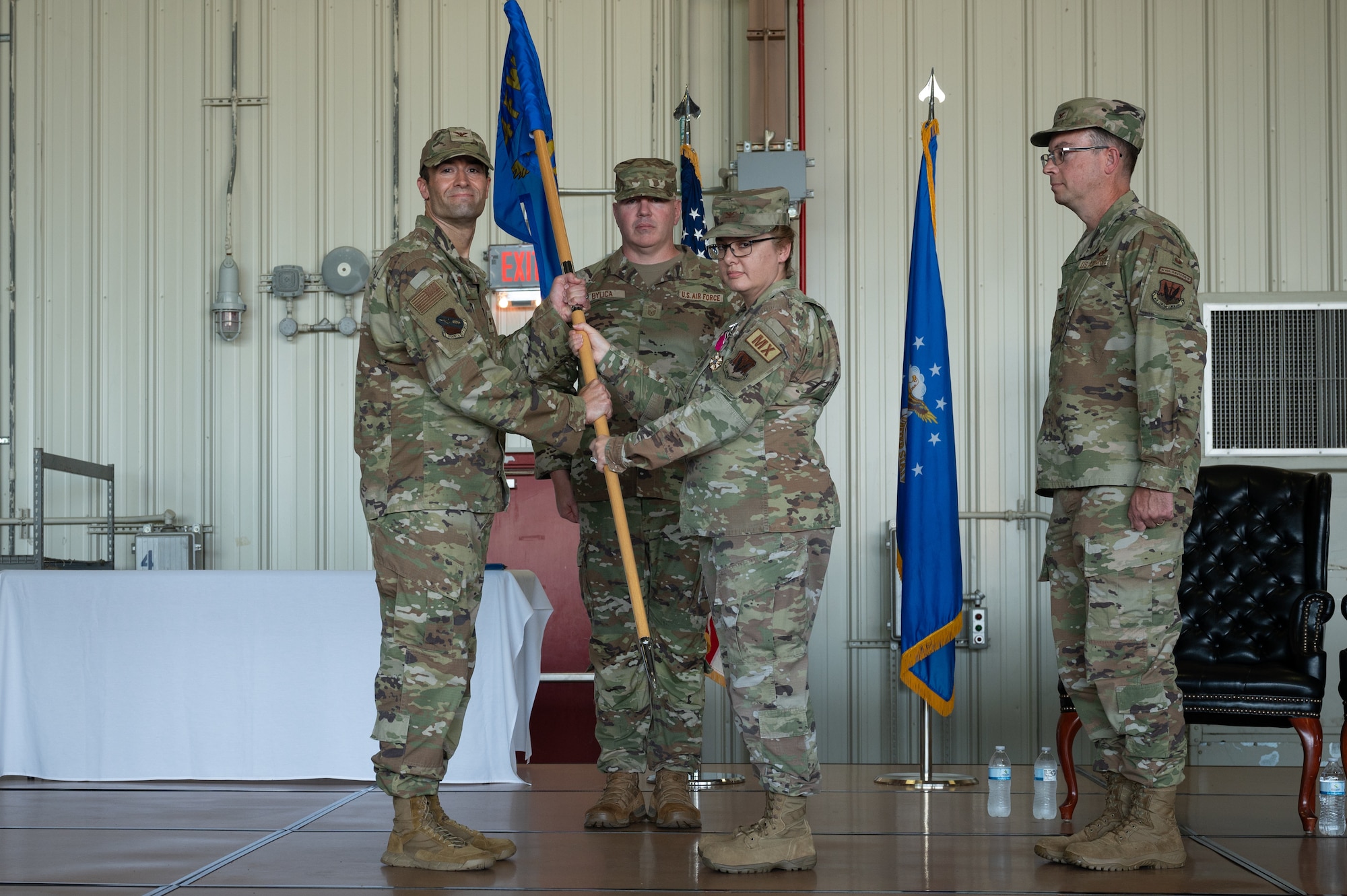 U.S. Air Force Col. Kathryn Roman, 4th Maintenance Group outgoing commander, right, passes the guidon from Col. Morgan Lohse, 4th Fighter Wing commander, during an assumption of command ceremony at Seymour Johnson Air Force Base, North Carolina, Aug. 2, 2024.The passing of a squadron’s guidon symbolizes the transfer of command. (U.S. Air Force photo by Senior Airman Rebecca Sirimarco-Lang)