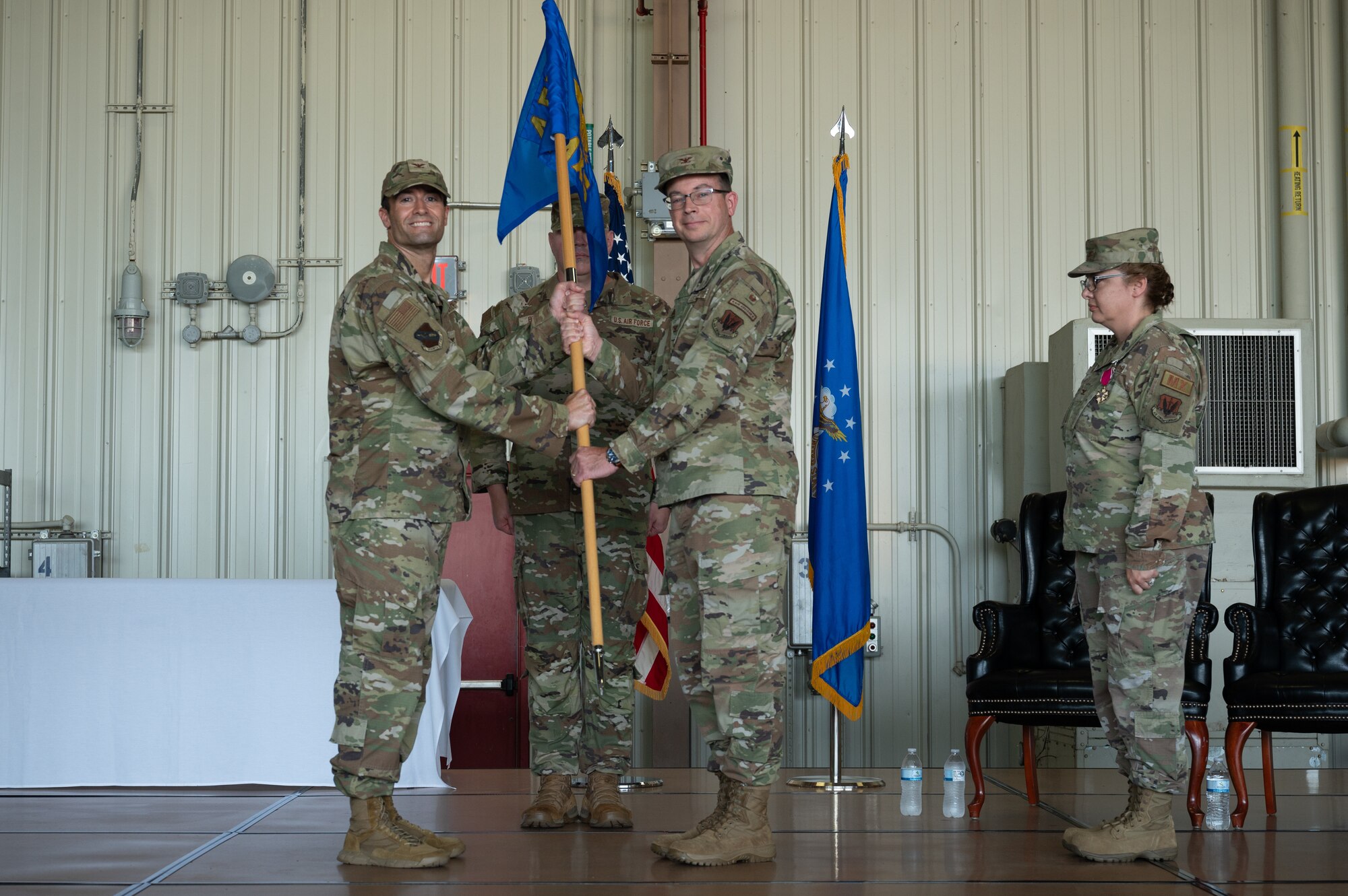 U.S. Air Force Col. Richard Boatman, 4th Maintenance Group incoming commander, right, takes the guidon from Col. Morgan Lohse, 4th Fighter Wing commander, during an assumption of command ceremony at Seymour Johnson Air Force Base, North Carolina, Aug. 2, 2024.The passing of a squadron’s guidon symbolizes the transfer of command. (U.S. Air Force photo by Senior Airman Rebecca Sirimarco-Lang)