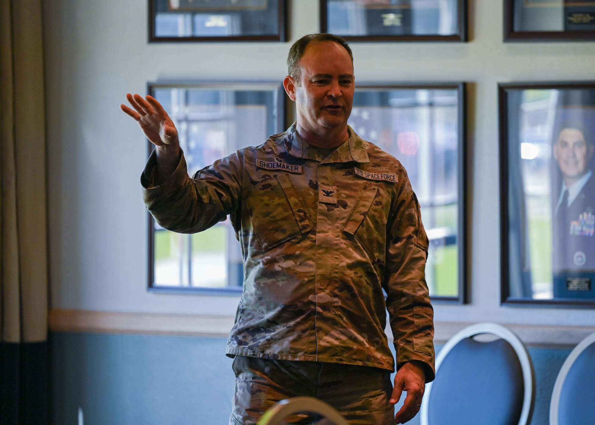 A man in uniform speaks to attendees of a meeting.