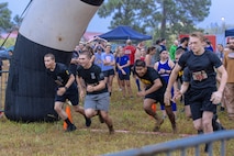 Soldiers run through an obstacle of the Marine Mud Challenge. Almost 700 participants showed up Sept. 14, 2024 to challenge their physical abilities to overcome and adapt to numerous obstacles on a four-mile course on Fort Eisenhower, Ga. as part of the Marine Mud Challenge.