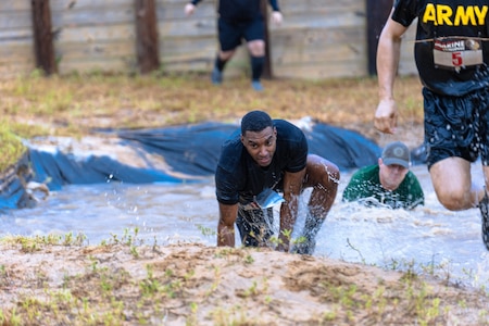 Almost 700 participants showed up Sept. 14, 2024 to challenge their physical abilities to overcome and adapt to numerous obstacles on a four-mile course on Fort Eisenhower, Ga. as part of the Marine Mud Challenge.  Here a group of Soldiers run through an obstacle.