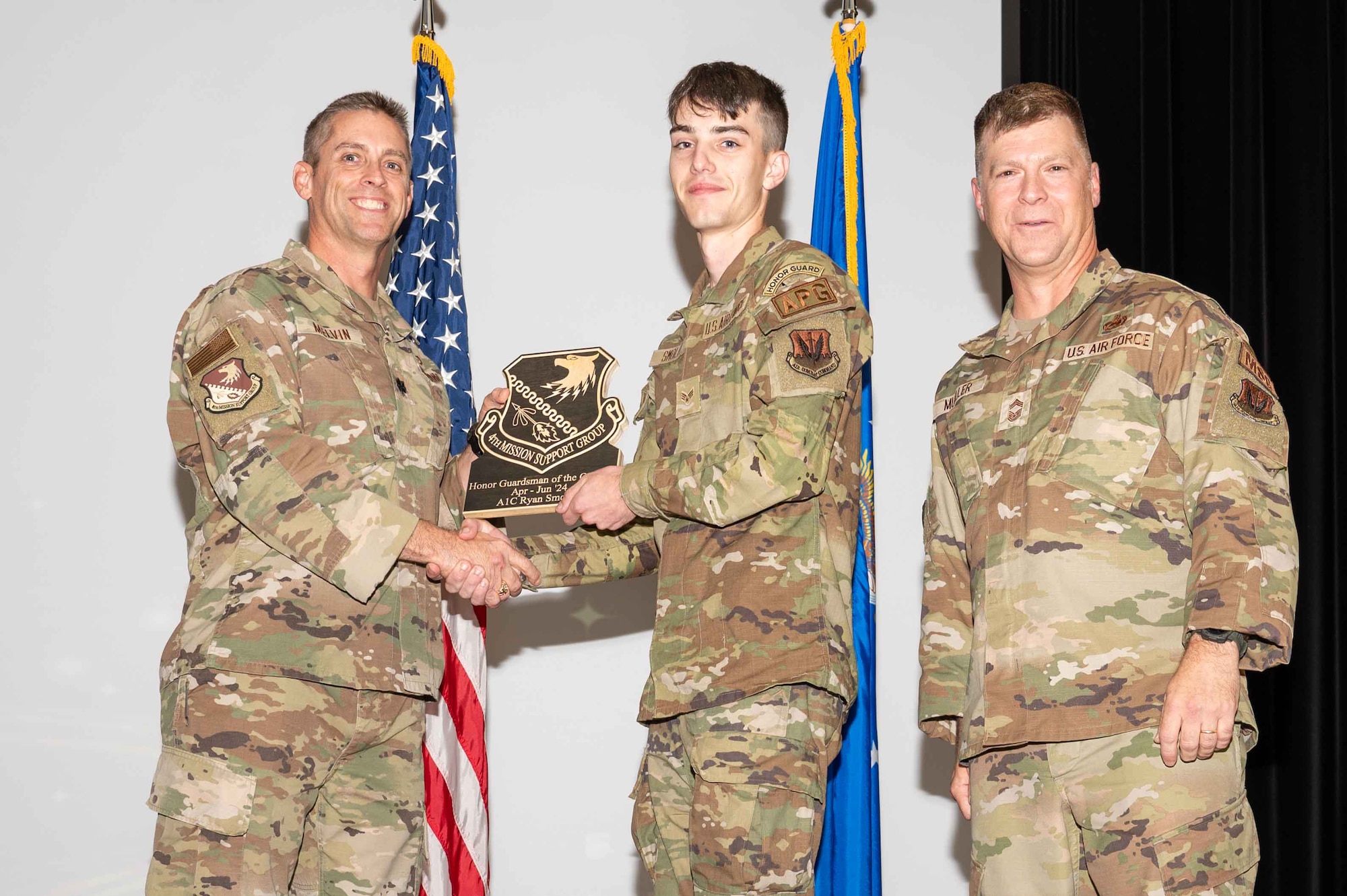 U.S. Air Force Airman 1st Class Ryan Smoley, 4th Fighter Wing Honor Guard honor guardsman, accepts the Honor Guardsman of the 2nd Quarter Award from Col. James Melvin, left, 4th Mission Support Group deputy commander, and Chief Master Sgt.  Edward Mueller, 4 MSG senior enlisted leader, during the 4 MSG 2nd Quarter Awards ceremony at Seymour Johnson Air Force Base, North Carolina, July 26, 2024. Quarterly Awards are awarded to Airmen and civilians in different categories including civilians and Airmen of the quarter. (U.S. Air Force photo by Airman 1st Class Rebecca Tierney)