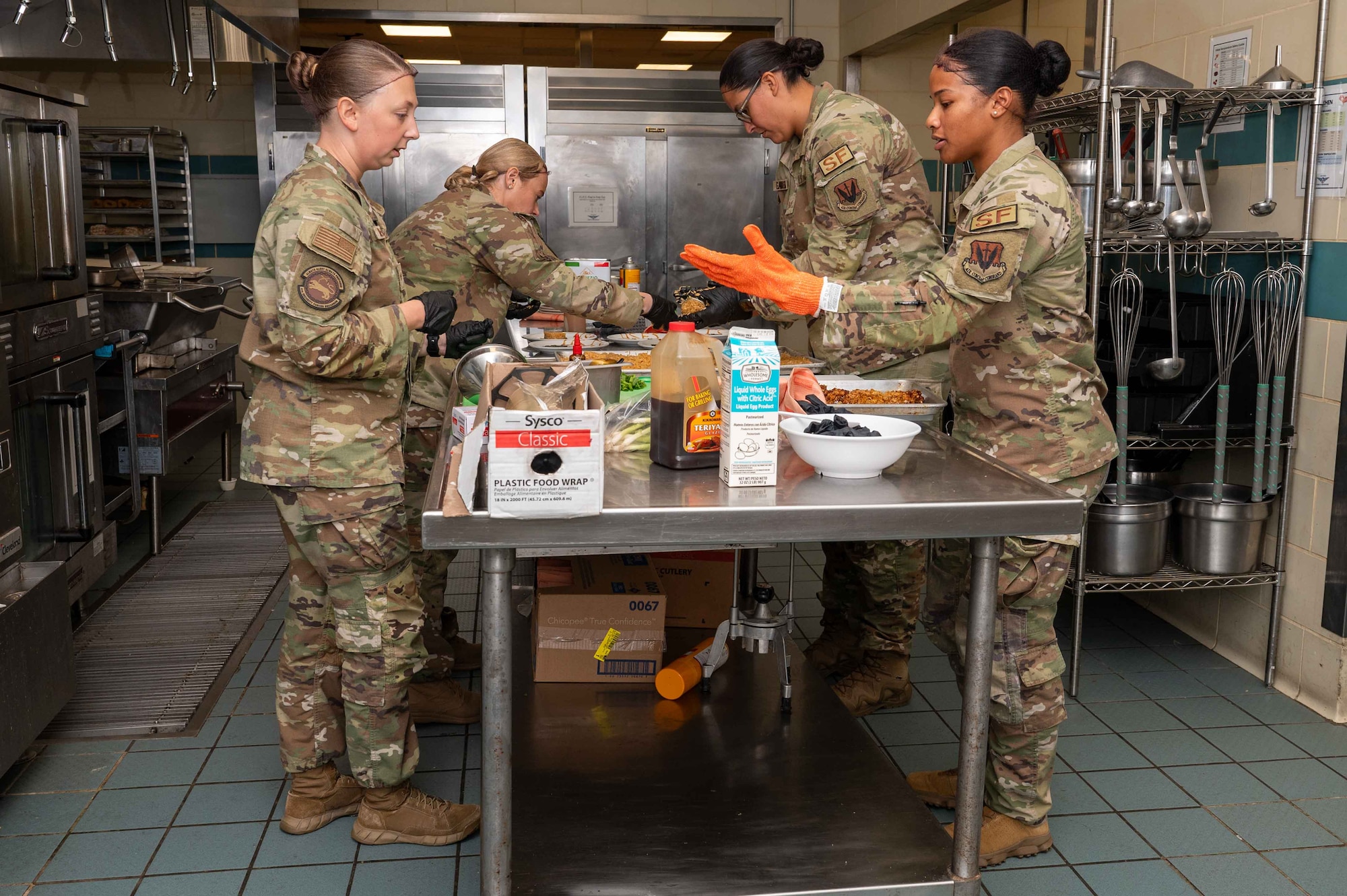 U.S. Air Force Airmen assigned to the 4th Security Forces Squadron converse amongst each other while prepping food during the “Battle of the MSG” cooking competition at the Southern Eagle Dining Facility on Seymour Johnson Air Force Base, North Carolina, Aug. 22, 2024. The competition was hosted by the 4th Force Support Squadron and promoted camaraderie as well as allowed the participants to showcase their culinary skills. (U.S. Air Force photo by Airman 1st Class Rebecca Tierney)