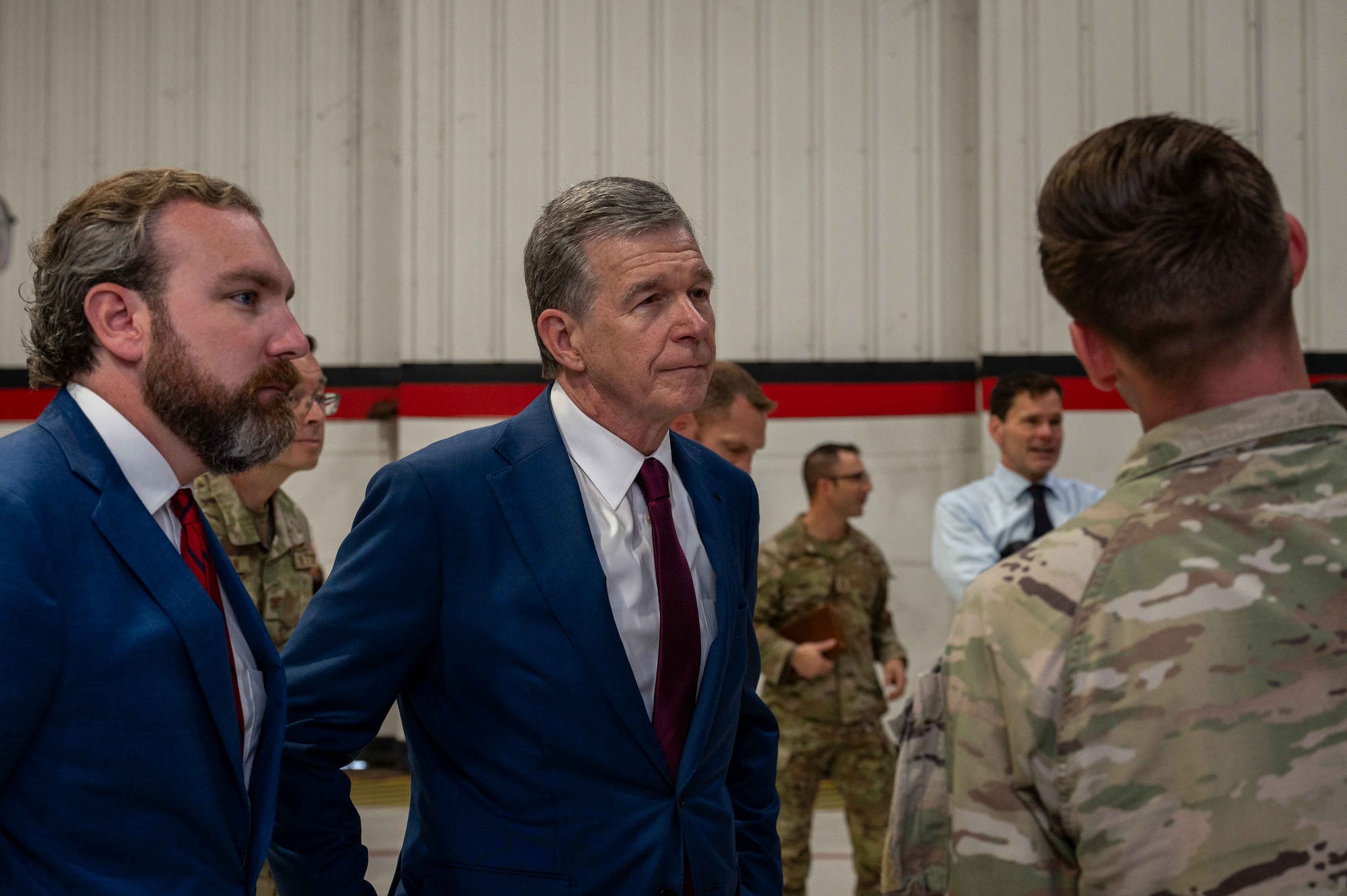 Governor Roy Cooper, Governor of North Carolina, converses with an Airman assigned to the 333rd Fighter Generation Squadron during a congressional delegate visit at Seymour Johnson Air Force Base, North Carolina, Aug. 29, 2024. Cooper received a brief regarding topics such as quality of life for Airmen, childcare, and much more. (U.S. Air Force photo by Airman 1st Class Rebecca Tierney)