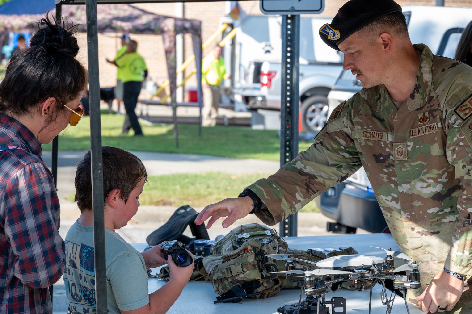 MSgt Ryan Schaefer, 4th SFS, explains the functions of law enforcement equipment to civilians during the NC Freedom Fest 2024.