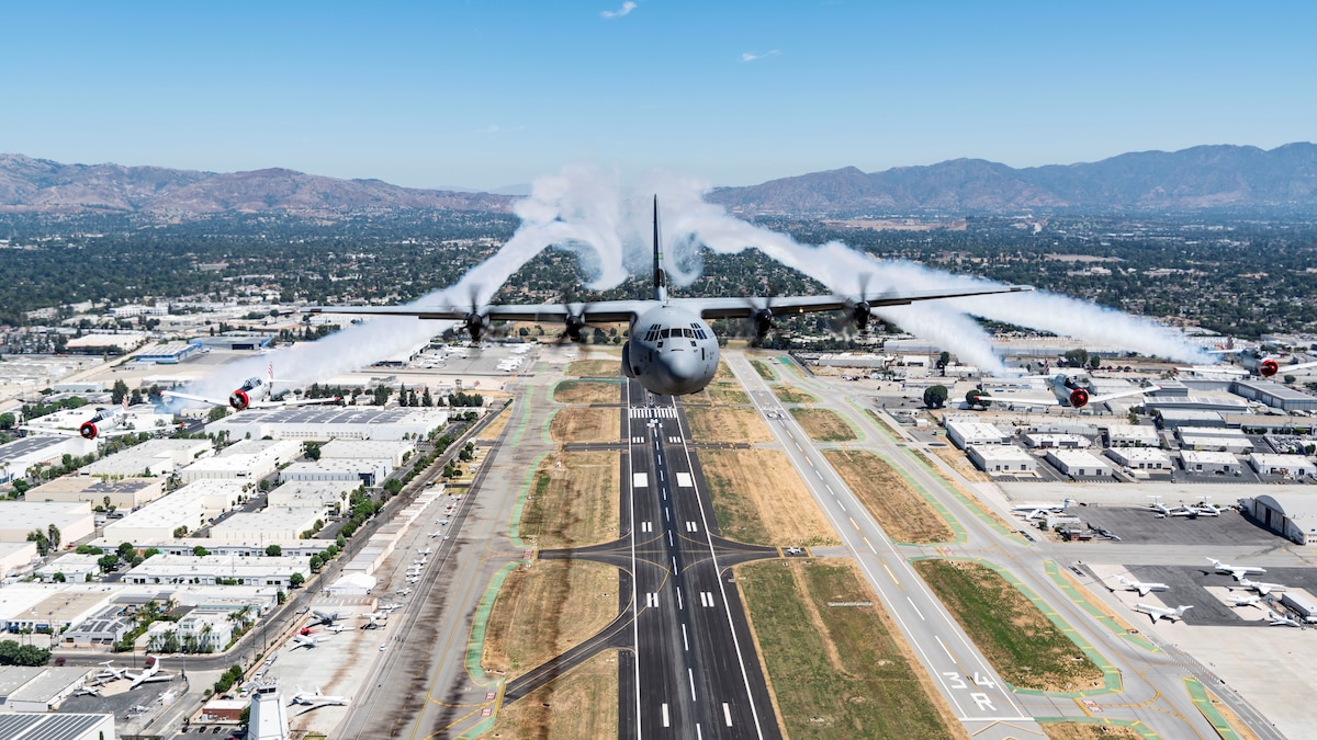 C-130J Super Hercules aircraft fly's above the Hollywood sign in a formation flight with other world war 2 aircraft.
