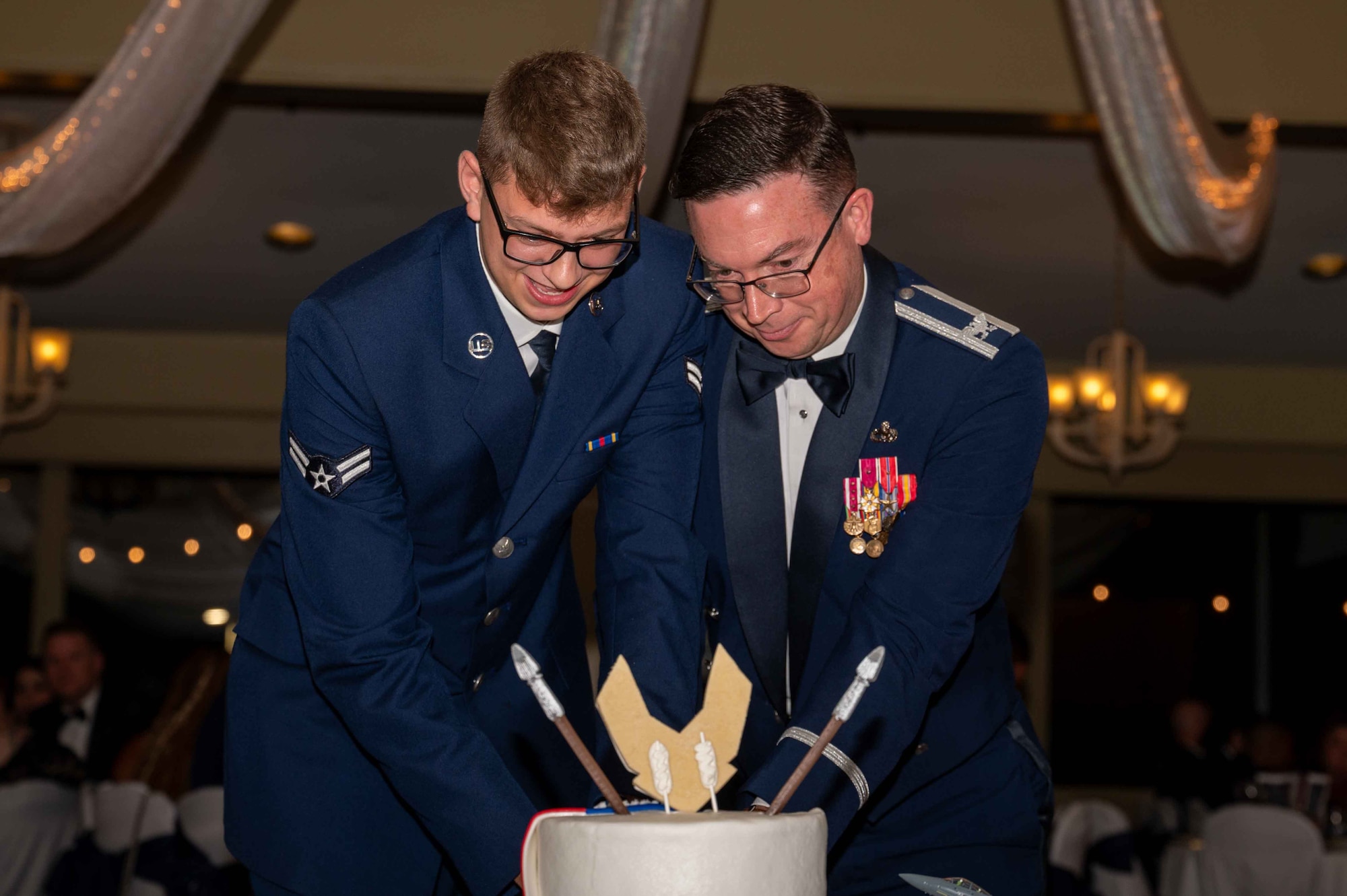U.S. Air Force Airmen assigned to the 4th Fighter Wing cut a cake during Seymour Johnson Air Force Base’s Ball at the Walnut Creek Country Club in Goldsboro, North Carolina, Sept. 14, 2024. The cake cutting is an annual tradition in which the oldest and youngest members in attendance cut the cake together. (U.S. Air Force photo by Airman 1st Rebecca Tierney)