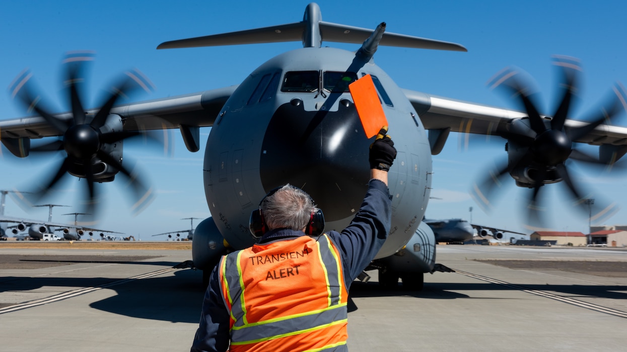 Airman directs foreign aircraft on flight line