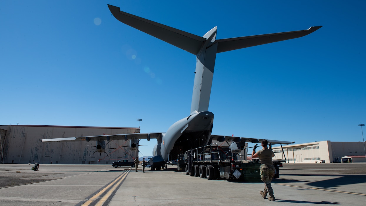 Overall of Airmen guiding loader away from aircraft on flight line