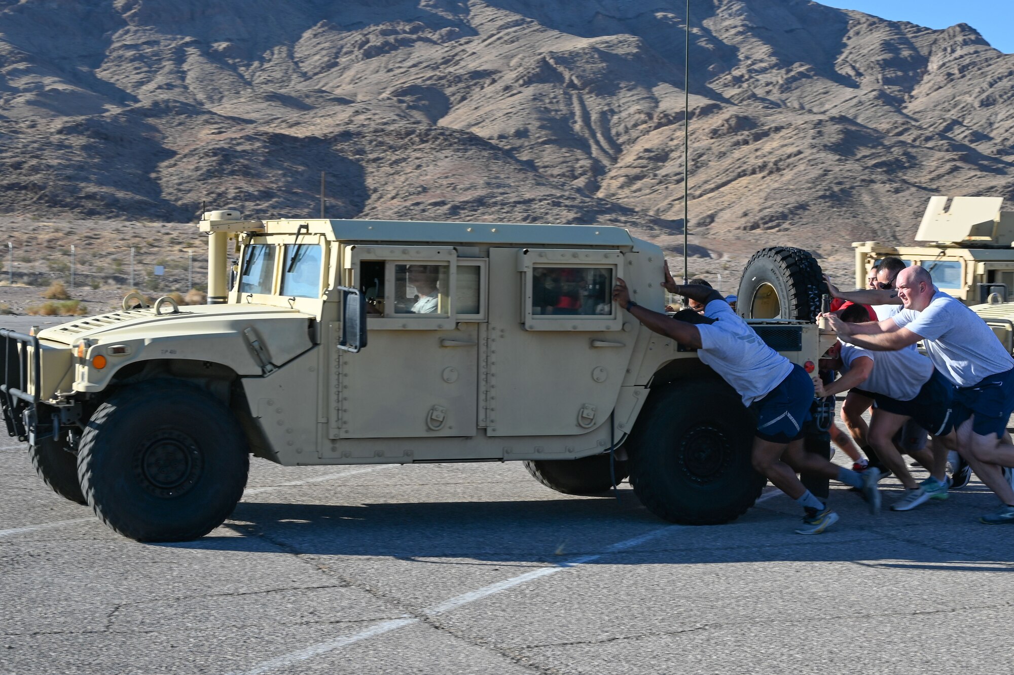 People pushing a vehicle.
