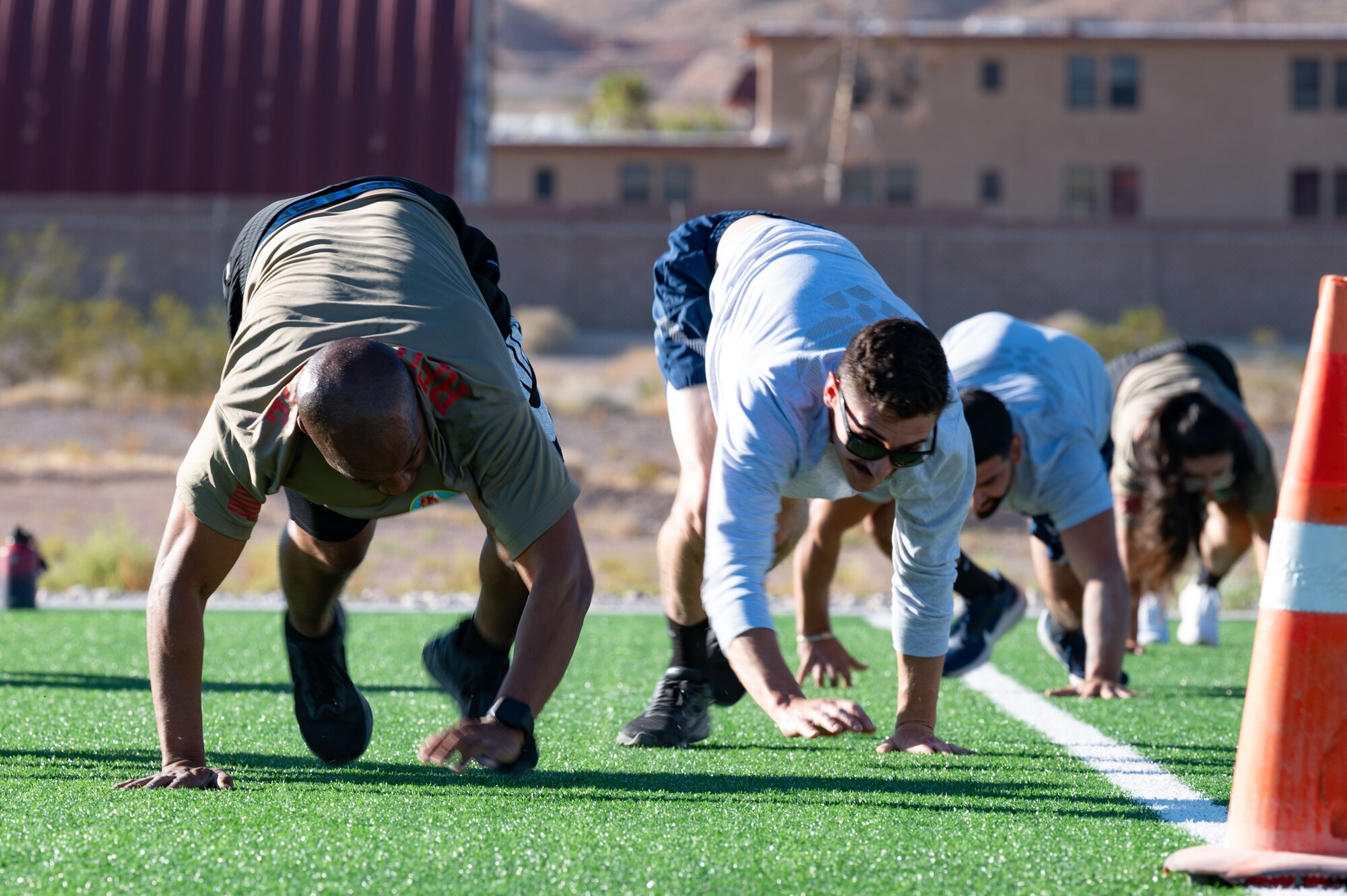 People bear crawling on turf.
