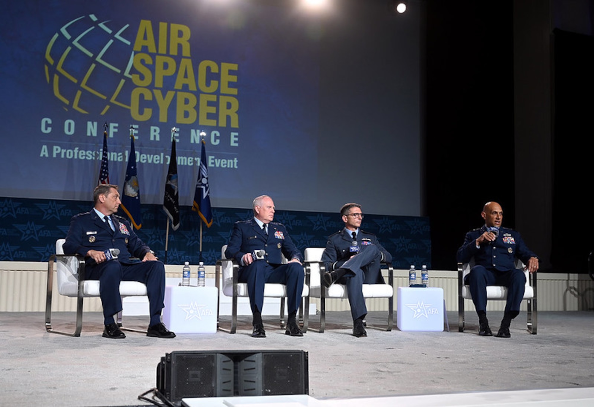 four people sitting on a big stage