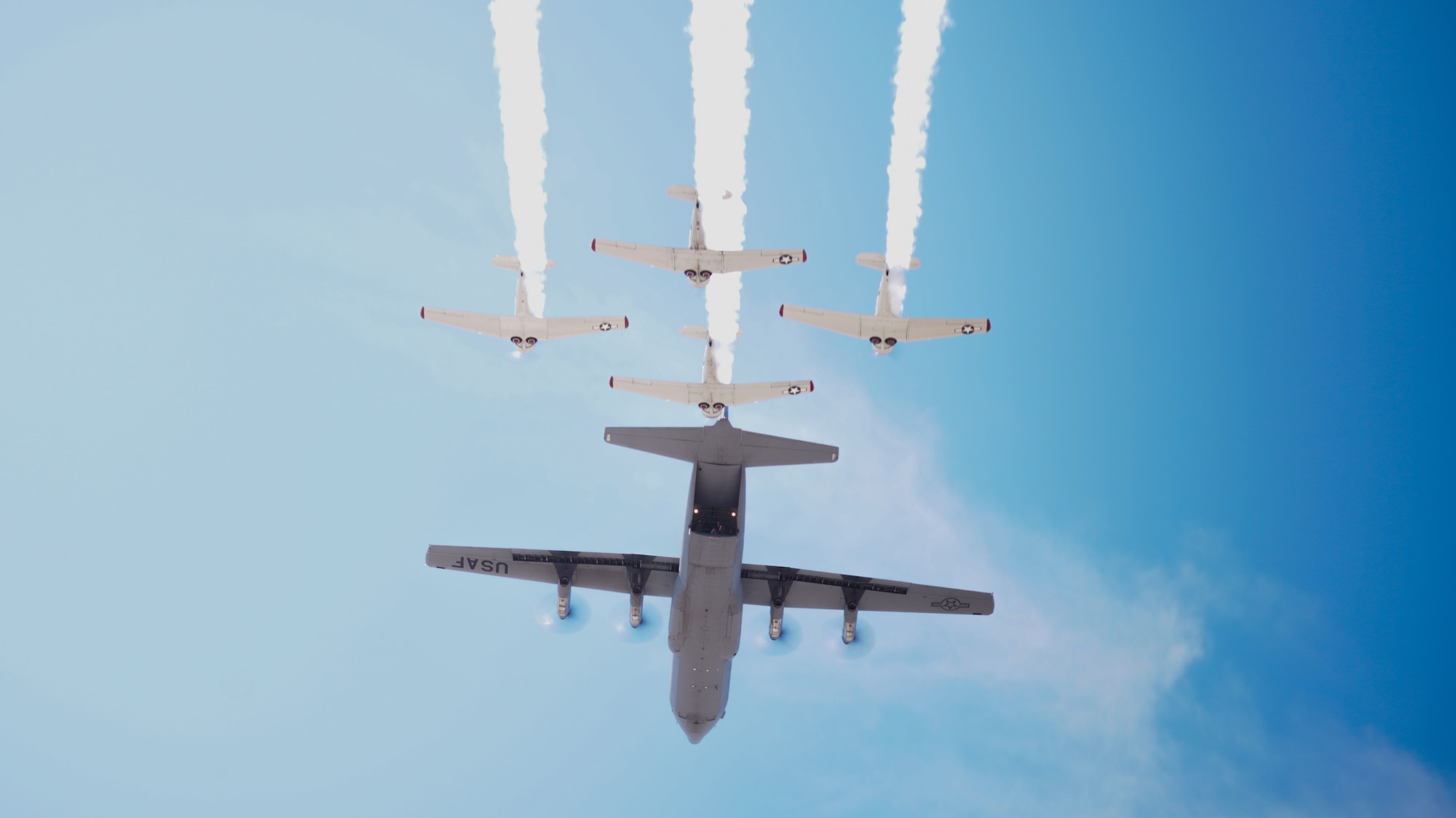 C-130J Super Hercules aircraft fly's above the Hollywood sign in a formation flight with other world war 2 aircraft.