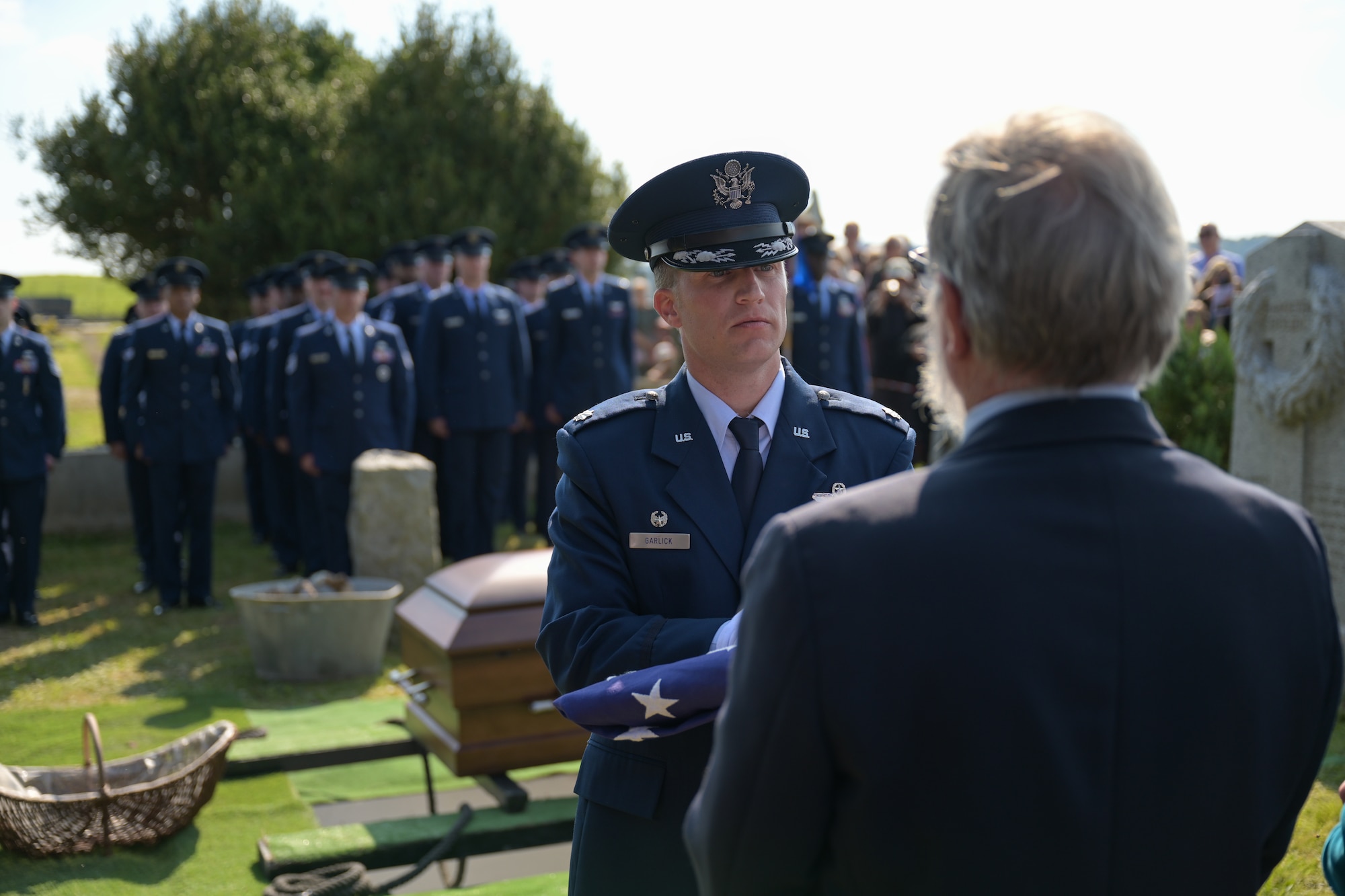 CHEVIÈRES, France – U.S. Air Force Lt. Col. Harrison Garlick, 94th Fighter Squadron Commander, presents the U.S. Flag to a family member during the reinterment of Capt. Hamilton Coolidge in Chevières, France, Sept. 15, 2024. The ceremony paid tribute to Coolidge’s service in World War I as a fighter pilot, killed in action in 1918. (U.S. Air Force photo by Staff Sergeant Nicole Molignano)