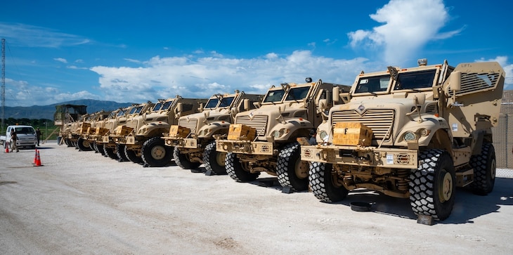 Military transport trucks lined up in a row.