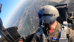 Air Force pilot in a jet flies over a city