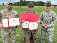 Three service members pose for a photo.
