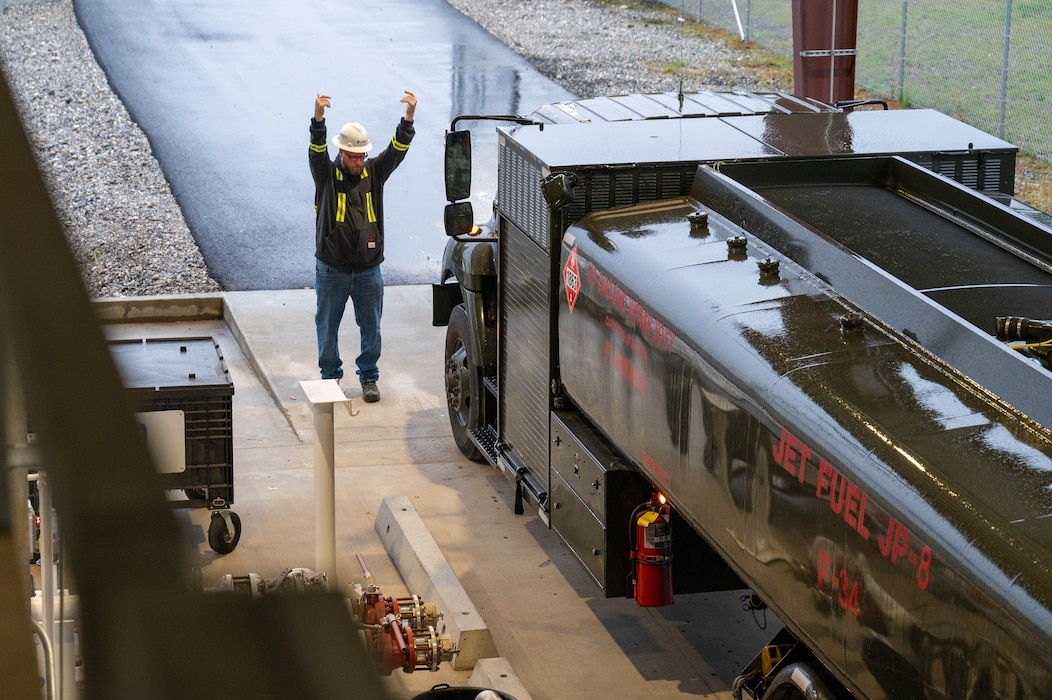 Heath Krogmann, Crowley Government Services terminal manager, marshals an R11 aircraft refueling vehicle, assigned to the 354th Logistics Readiness Squadron, at the Defense Fuel Supply Point in North Pole, Alaska, Sept. 13, 2024.