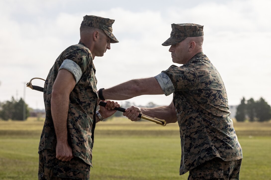 U.S. Marine Corps Lt. Col. Adam S. Young, left, the commanding officer of 2d Battalion, 2d Marine Regiment, 2d Marine Division, receives the noncommissioned officer sword from Sgt. Maj. Ryan D. Cantrell, a native of Kentucky and the outgoing sergeant major, during a relief and appointment ceremony on Marine Corps Base Camp Lejeune, North Carolina, Sept. 6, 2024. During the ceremony, Cantrell relinquished his role of battalion sergeant major to Sgt. Maj. Roberto A. Brown. (U.S. Marine Corps photo by Lance Cpl. Brian Bolin Jr.)