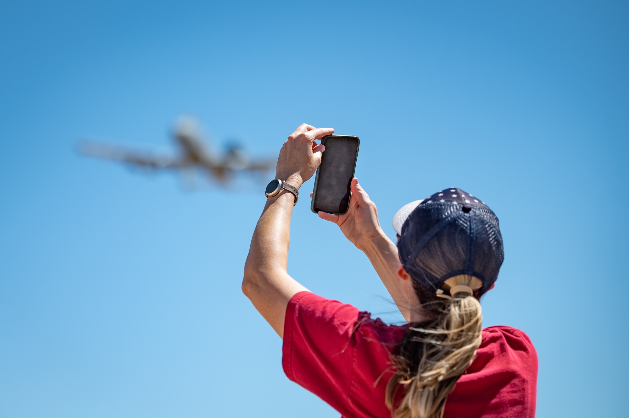 Melissa Wastell, daughter of a retired A-10 pilot from the Vietnam era, captures a moment as an A-10 Thunderbolt II flies overhead during Hawgsmoke 2024 at the Barry M. Goldwater Range near Gila Bend, Ariz., on Sept. 13, 2024. Wastell, a Phoenix resident, shared her deep connection to the A-10 community, describing the aircraft as a tribute to her father's legacy. (U.S. Air Force photo by Tech. Sgt. Tyler J. Bolken)
