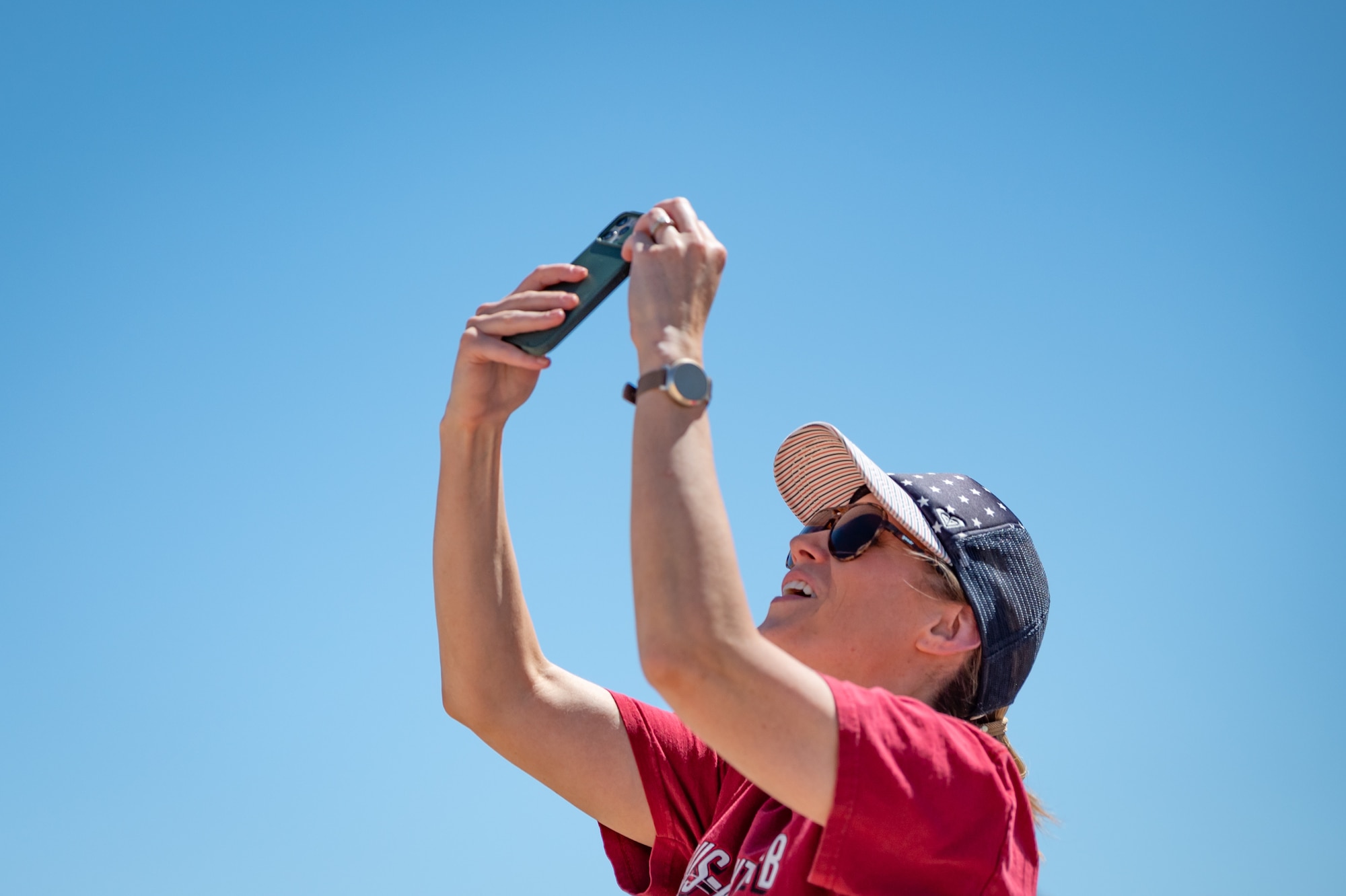 Melissa Wastell, daughter of a retired A-10 pilot from the Vietnam era, captures a moment as an A-10 Thunderbolt II flies overhead during Hawgsmoke 2024 at the Barry M. Goldwater Range near Gila Bend, Ariz., on Sept. 13, 2024. Wastell, a Phoenix resident, shared her deep connection to the A-10 community, describing the aircraft as a tribute to her father's legacy. (U.S. Air Force photo by Tech. Sgt. Tyler J. Bolken)