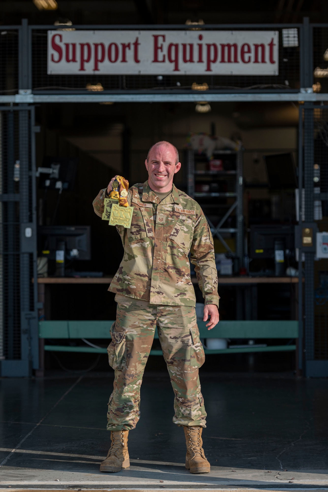 a man in uniform holds up gold medals