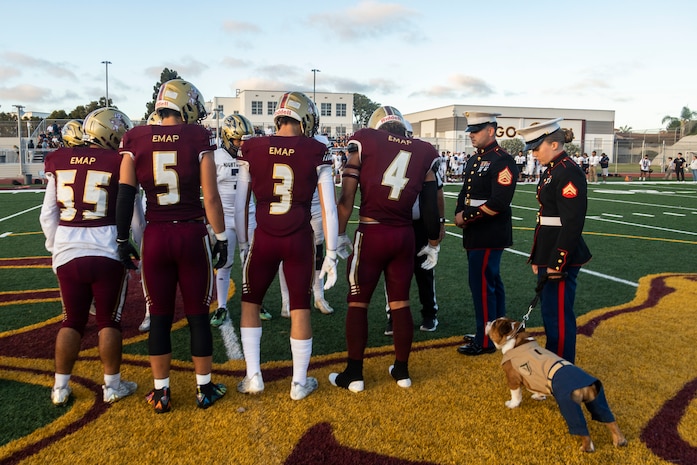 U.S. Marine Corps Staff Sgt. Evan Nichols, a canvassing recruiter with Recruiting Sub-Station National City, Recruiting Station San Diego, participates in the coin toss during a military appreciation night at Point Loma High School in San Diego, Aug. 23, 2024. The military appreciation night was held to honor military service members and foster community connections. (U.S. Marine Corps photo by Staff Sgt. Jesula Jeanlouis)